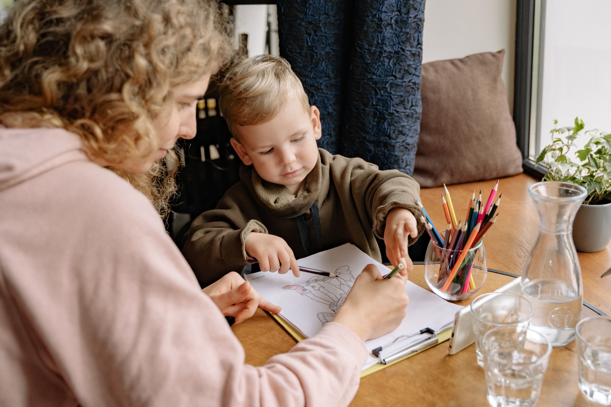 A child and adult drawing together at a table